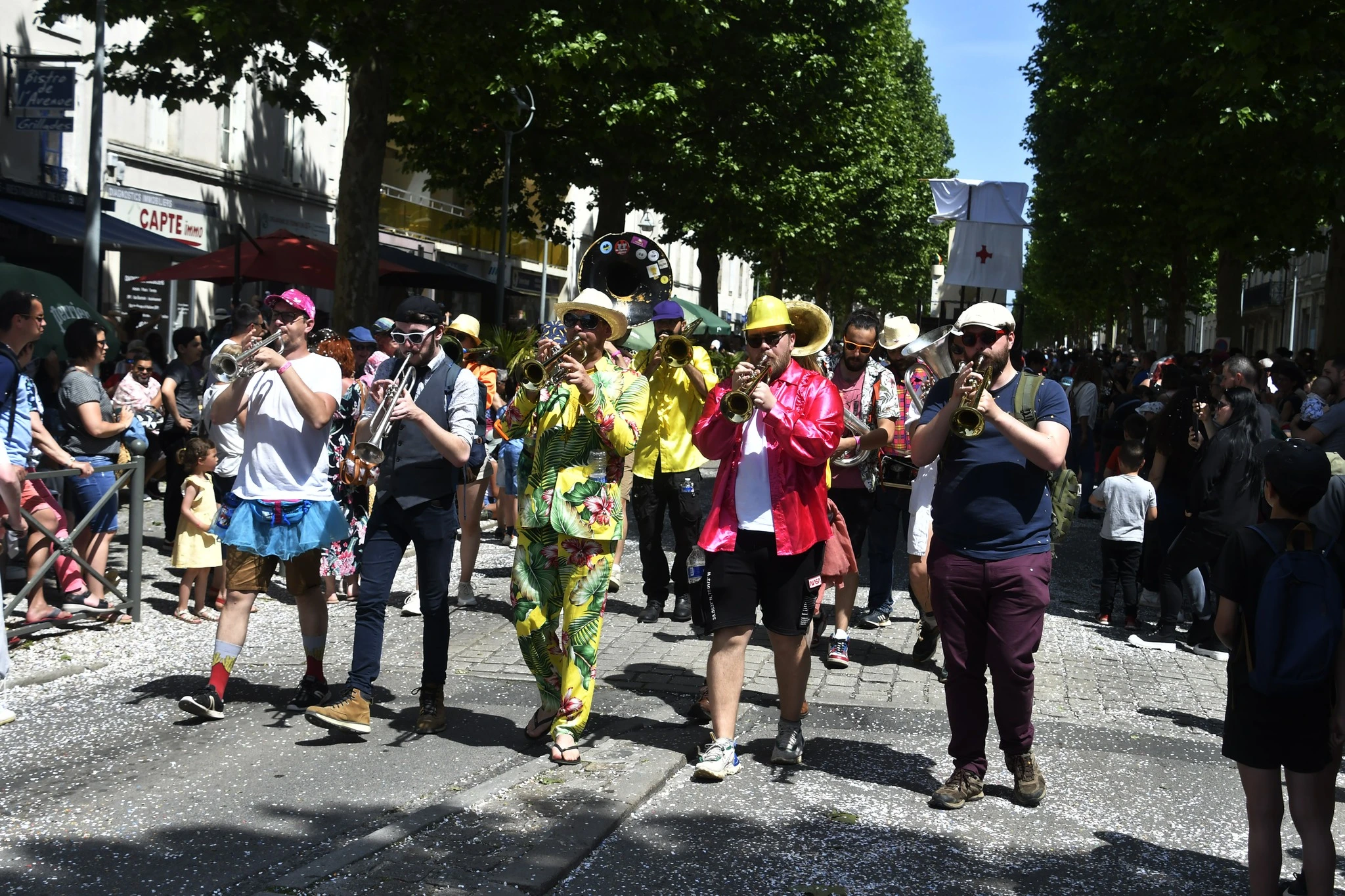 Cinq trompettistes de la fanfare des Chiures de Mouches jouent en première ligne lors d'un carnaval